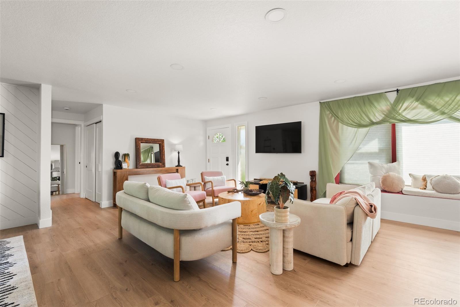 6115 Chase Street Arvada, CO 80003 - Photo 9 of 45 a living room with furniture a large window and a flat screen tv