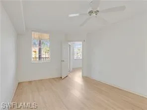 an empty room with a window and ceiling fan