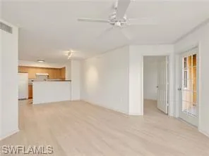 a view of a livingroom with a ceiling fan & entryway