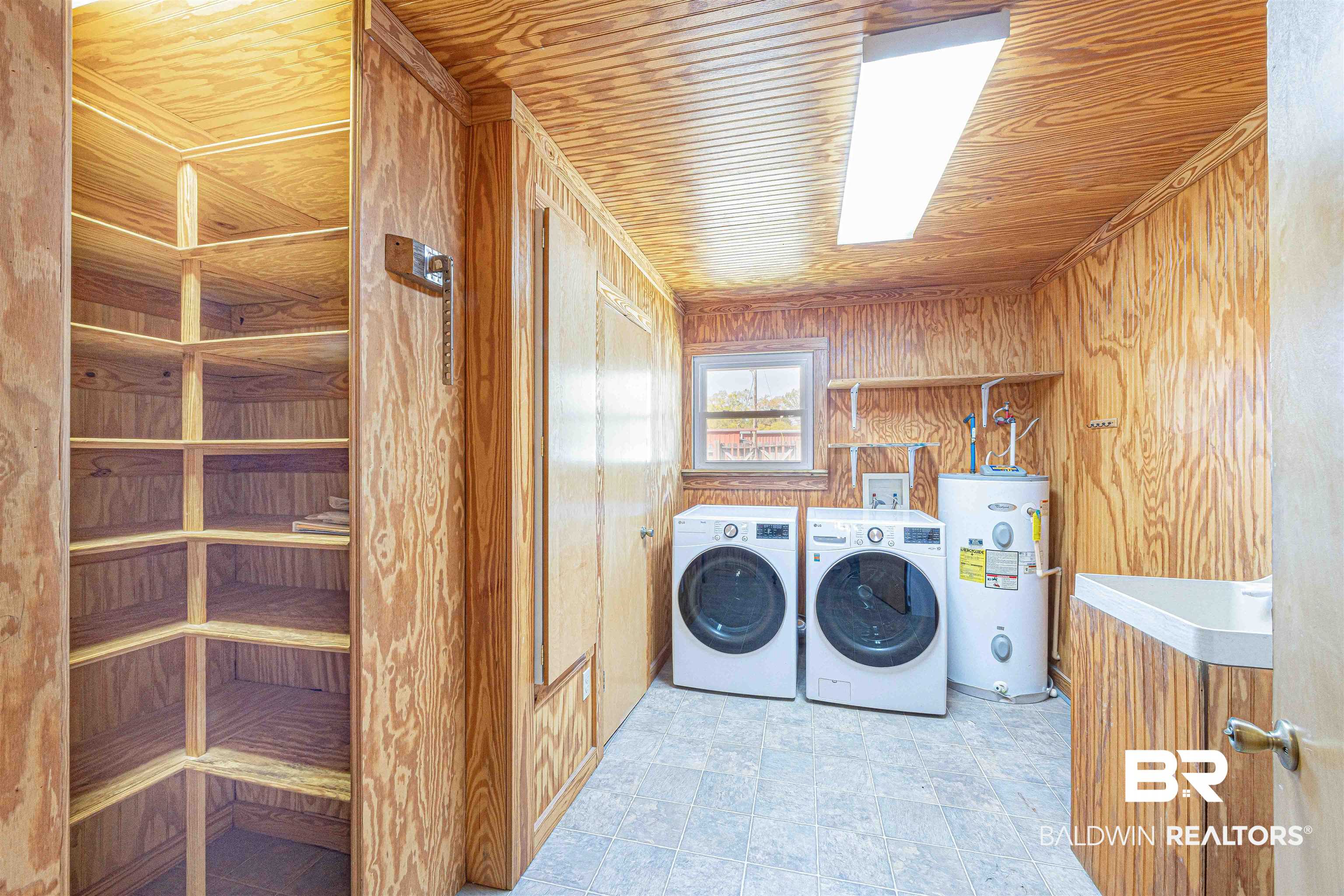 43101 Brown Road Bay Minette, AL 36507 - Photo 19 of 81 Laundry room featuring wood walls, water heater, wood ceiling, washer and dryer, and stone finish floors