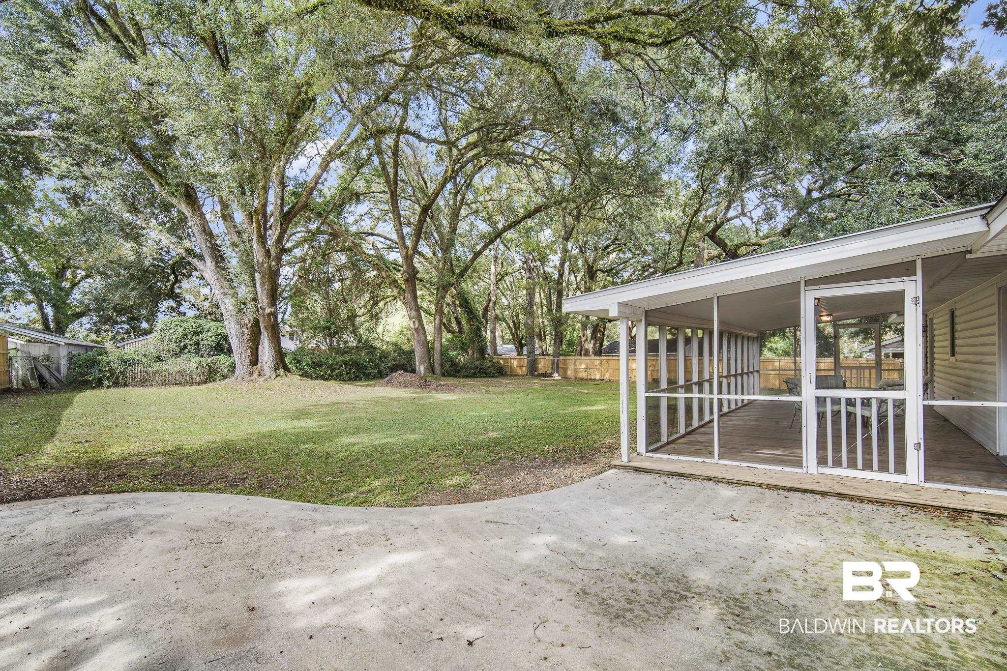 103 Ann Street Daphne, AL 36527 - Photo 20 of 23 View of yard featuring a sunroom and view of scattered trees
