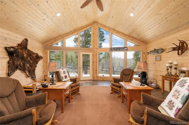 a living room with furniture and floor to ceiling windows