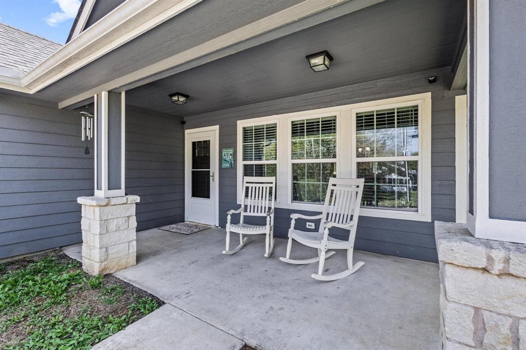 608 East Shepherd Street Denison, TX 75021 - Photo 4 of 31 Inviting covered front porch with concrete flooring, accented by stone column bases and a white paneled entry door