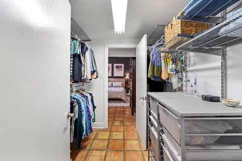 a view of walk in closet with clothes and shoes