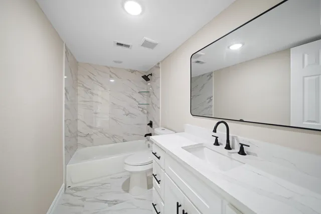 a bathroom with a sink toilet and shower