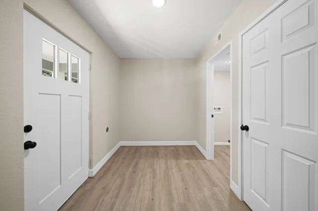 a view of a room with wooden floor and a hallway