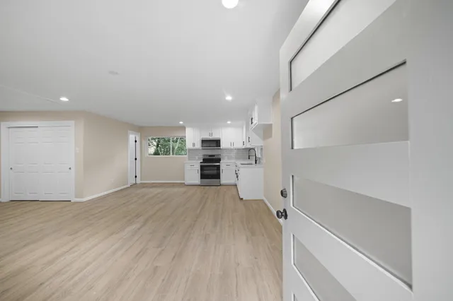 a view of a kitchen with wooden floor and a sink