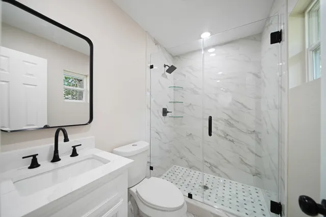 a bathroom with a sink toilet and shower