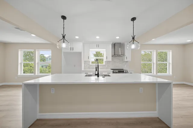 a kitchen with stainless steel appliances granite countertop a sink a window and wooden floor