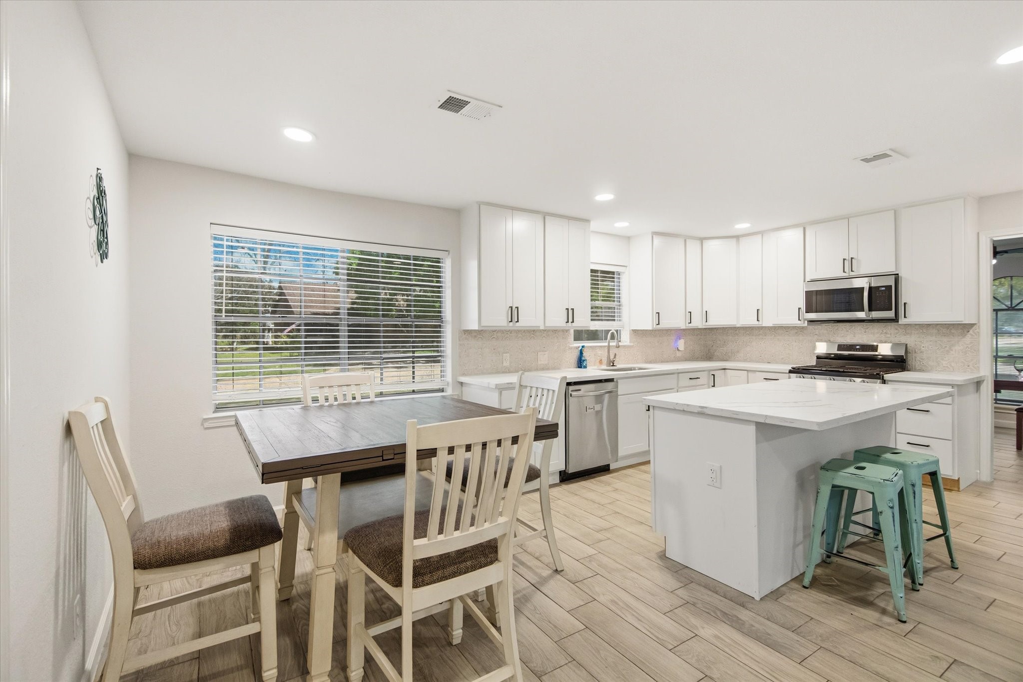 113 Rose Trail Lake Jackson, TX 77566 - Photo 12 of 45 a kitchen with white cabinets and chairs