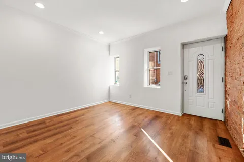 a view of an empty room with wooden floor