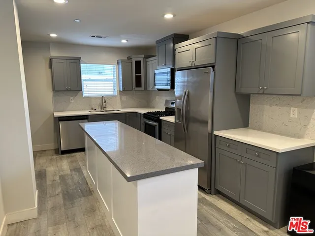 a kitchen with a sink a refrigerator and cabinets