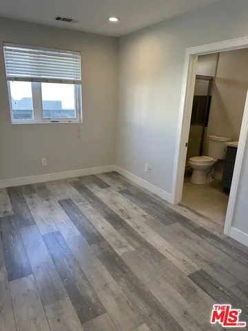 an empty room with wooden floor and mirror