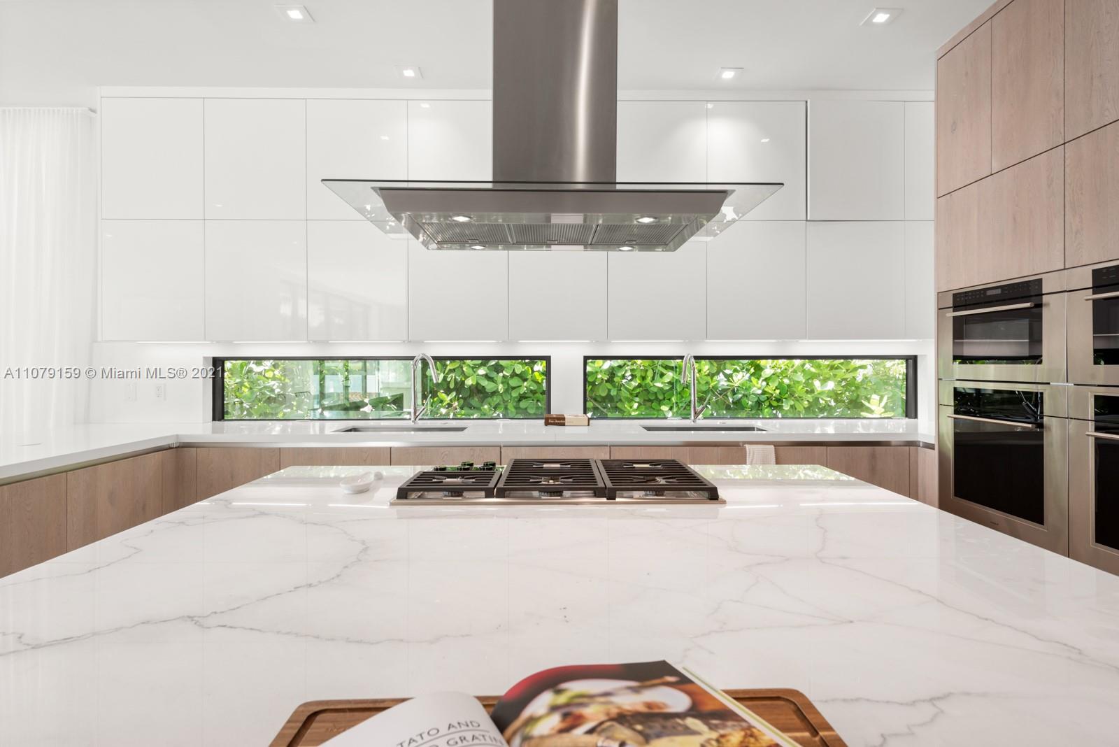 1413 Biscaya Drive Surfside, FL 33154 - Photo 13 of 35 a kitchen with stainless steel appliances kitchen island granite countertop a sink and a stove