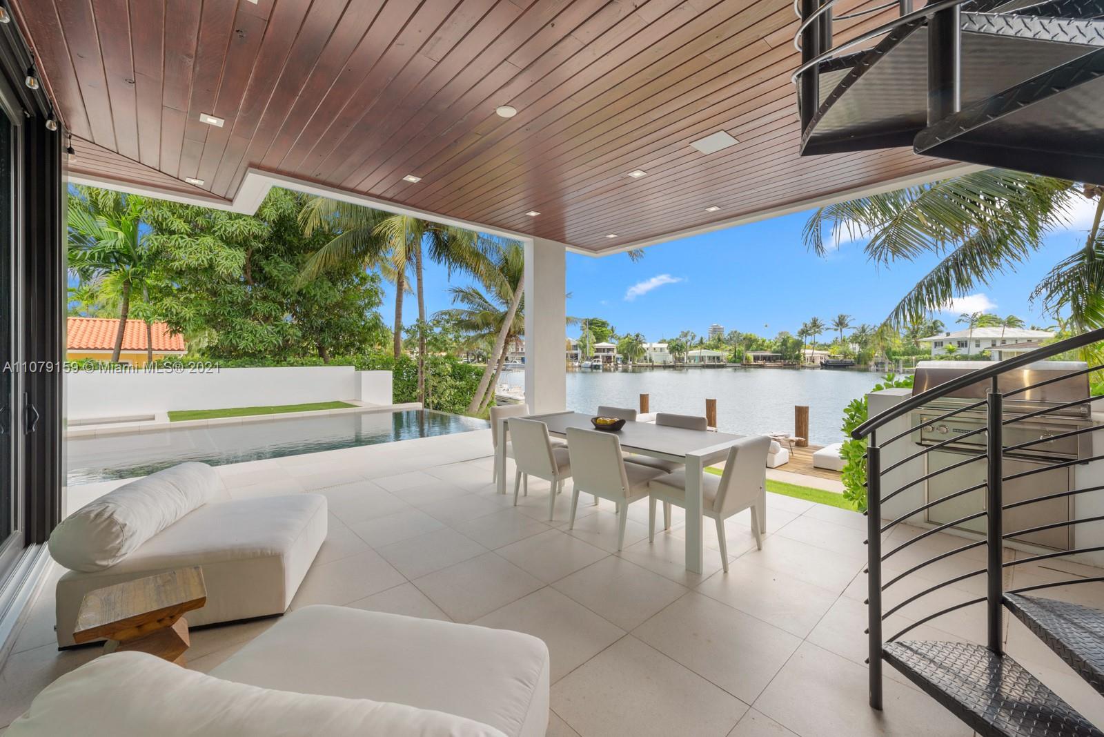 1413 Biscaya Drive Surfside, FL 33154 - Photo 29 of 35 a view of a patio with couches table and chairs and potted plants