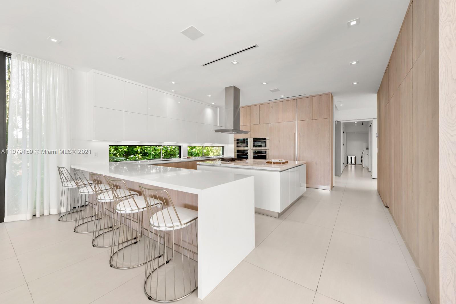 1413 Biscaya Drive Surfside, FL 33154 - Photo 10 of 35 a kitchen with a white table and chairs in it