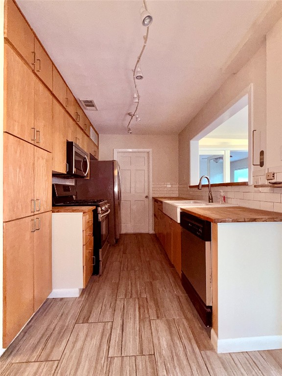 5413 Coventry Lane Austin, TX 78723 - Photo 5 of 25 a kitchen with stainless steel appliances granite countertop a sink a stove cabinets and wooden floor