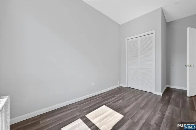 an empty room with wooden floor and closet