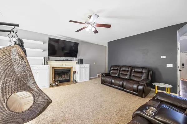 a living room with furniture a fireplace and a flat screen tv