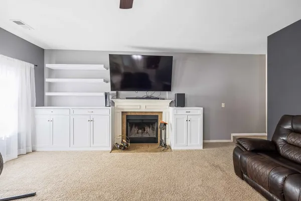 a living room with furniture a flat screen tv and a fireplace