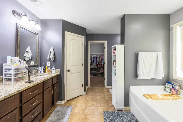 a bathroom with a tub sink and mirror