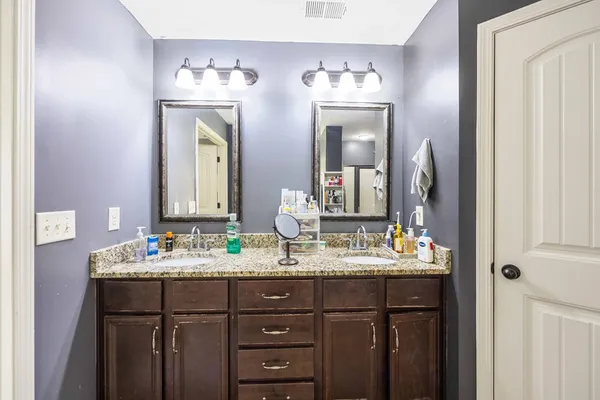 a bathroom with a double vanity sink and a mirror