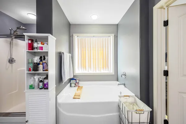 a bathroom with a tub sink and a window