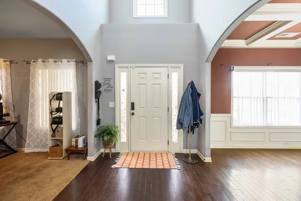 a view of front door with hallway and wooden floor