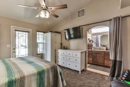 1220 Jennifer Court Ridgecrest, CA 93555 - Photo 22 of 34 a spacious bedroom with a bed and a flat screen tv