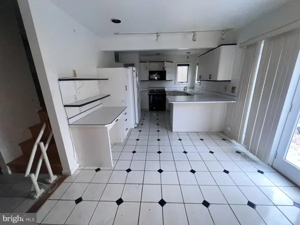 a kitchen with white cabinets and white appliances