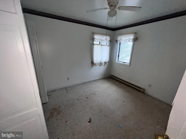 an empty room with a window and a mirror