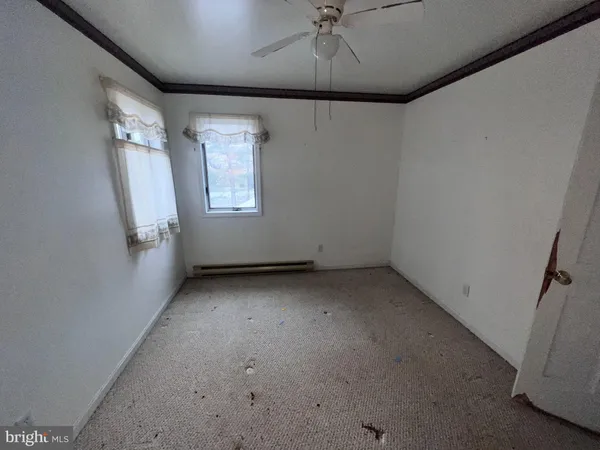 an empty room with a ceiling fan and window