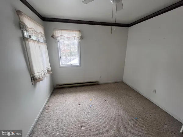 an empty room with a ceiling fan and window