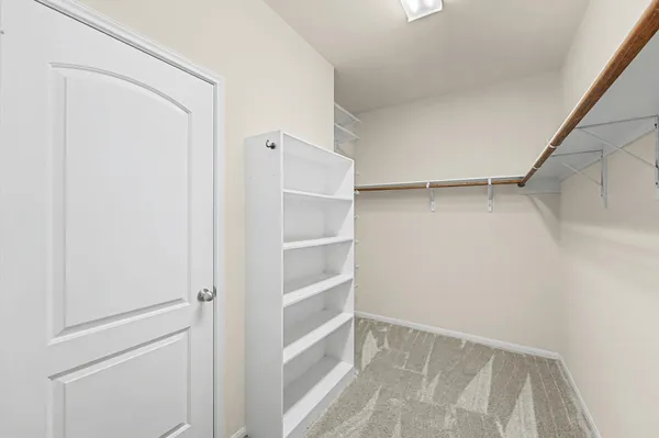 a view of walk in closet with empty racks