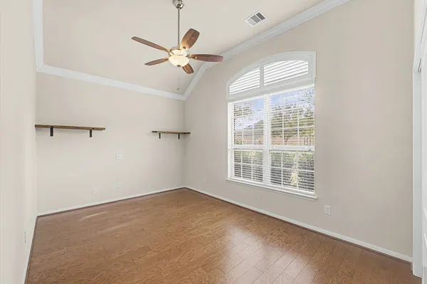 an empty room with windows and fan