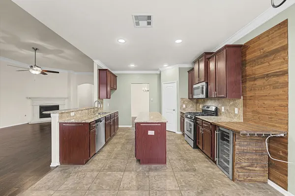 a large kitchen with stainless steel appliances granite countertop a stove a sink dishwasher and a refrigerator