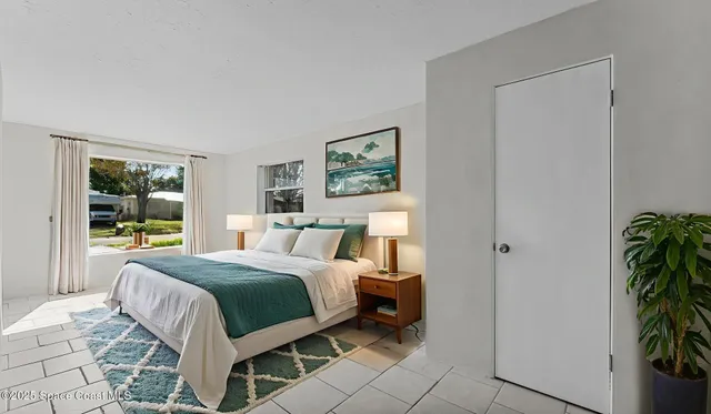 a bedroom with a bed lamp and a potted plant