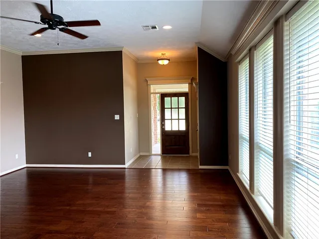 a view of a livingroom with wooden floor and a ceiling fan