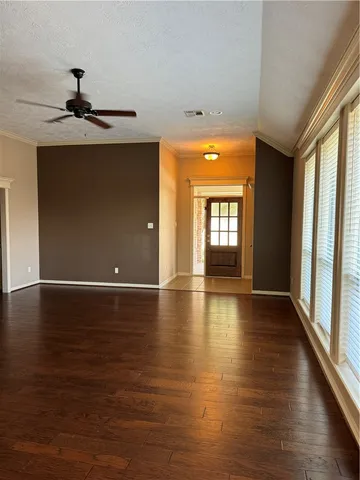 an empty room with wooden floor a fireplace and window