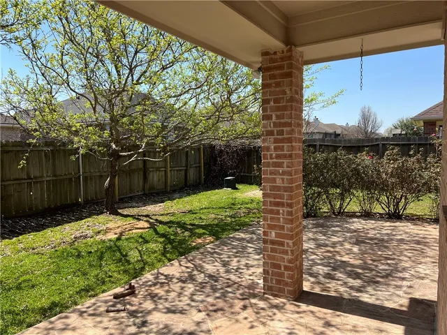 a view of a yard with wooden fence