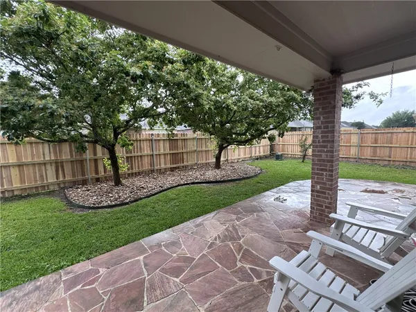 a view of brick house with a small yard