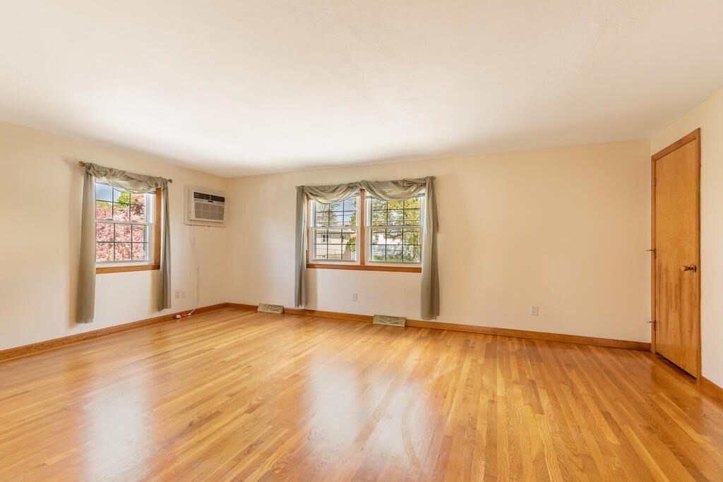 76 Hally Road Lowell, MA 01854 - Photo 8 of 36 an empty room with wooden floor and windows