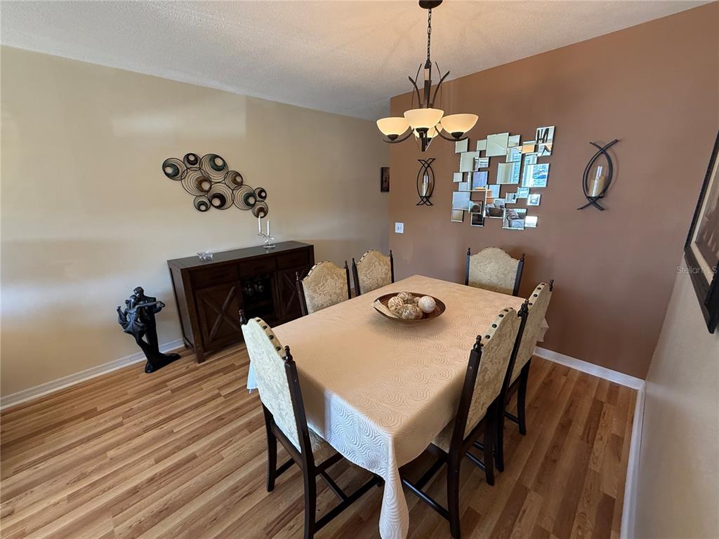 2460 Canadian Way, Unit 22 Clearwater, FL 33763 - Photo 8 of 42 a view of a dining room with furniture wooden floor and a chandelier