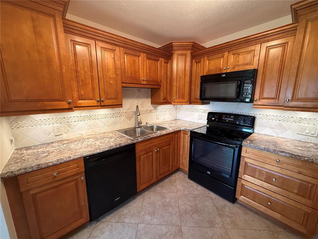 2460 Canadian Way, Unit 22 Clearwater, FL 33763 - Photo 10 of 42 a kitchen with granite countertop a refrigerator stove top oven and sink