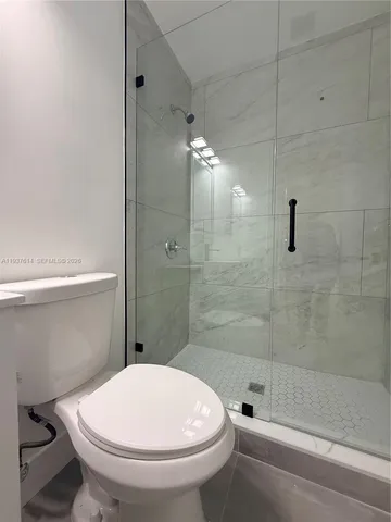 a bathroom with a toilet and a shower