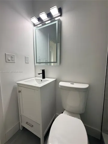 a white toilet sitting next to a bathroom sink