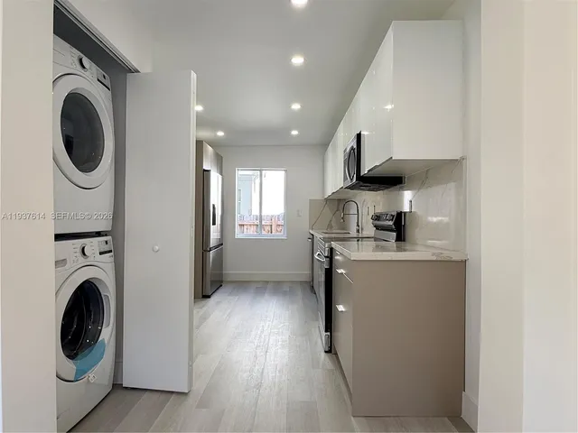 a kitchen with a washer and dryer in it