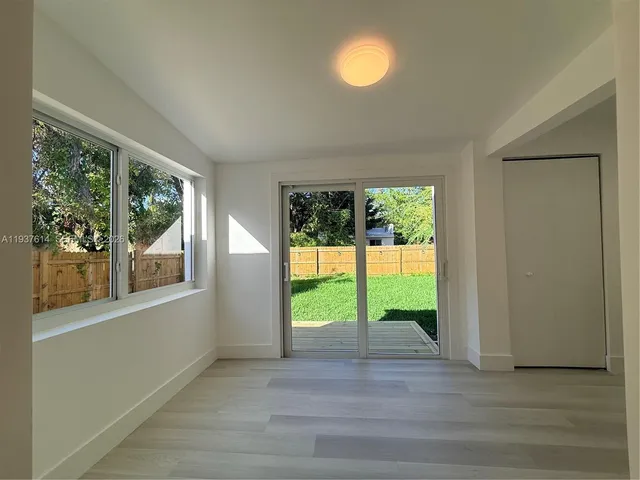 a view of an entryway with wooden floor and garden