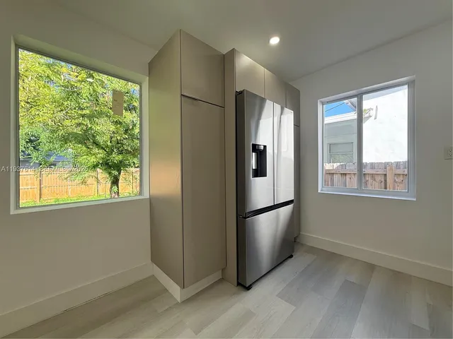 a kitchen with stainless steel appliances granite countertop a refrigerator and a window