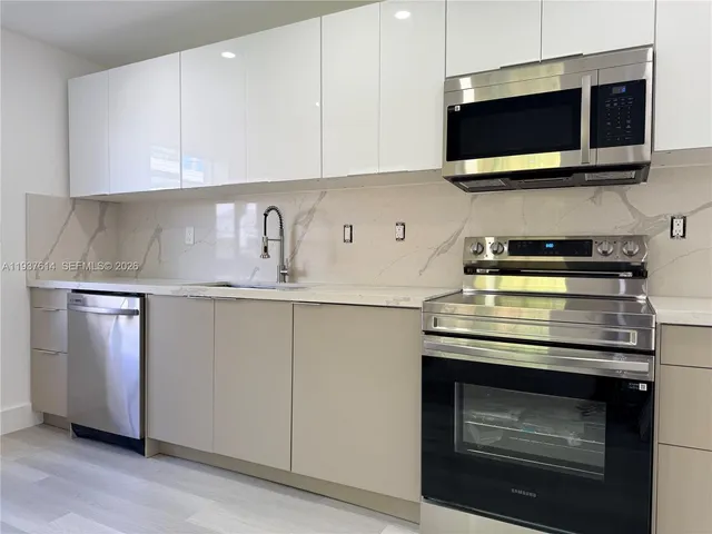 a kitchen with stainless steel appliances granite countertop a stove and a microwave